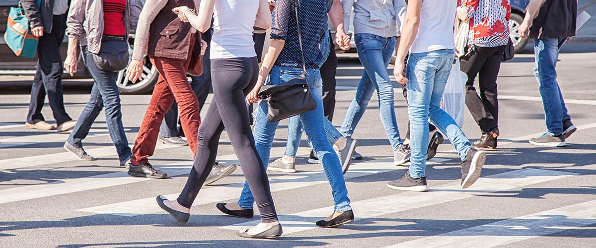 Fußgängerinnen laufen über einen Zebrastreifen als Symbol für Fußgänger im Verkehrsrecht