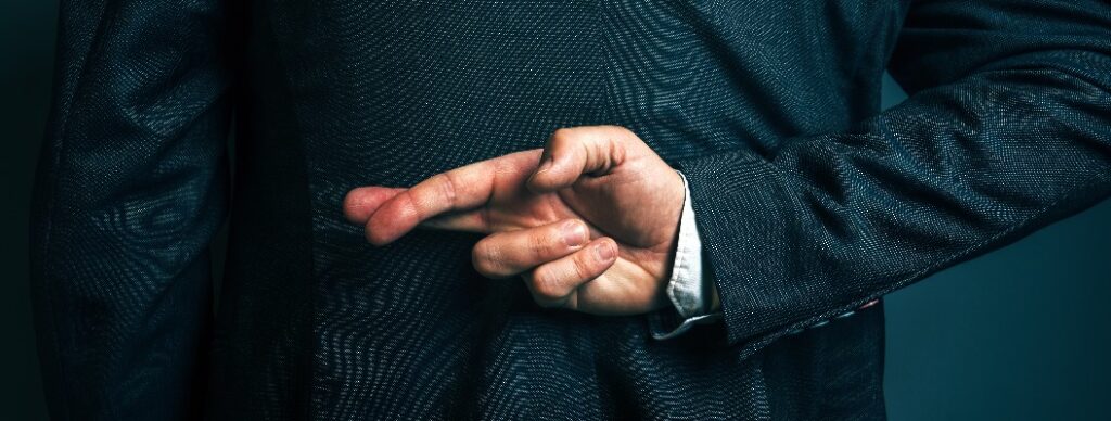 Lügender Geschäftsmann, der hinter seinem Rücken die Finger gekreuzt hält.