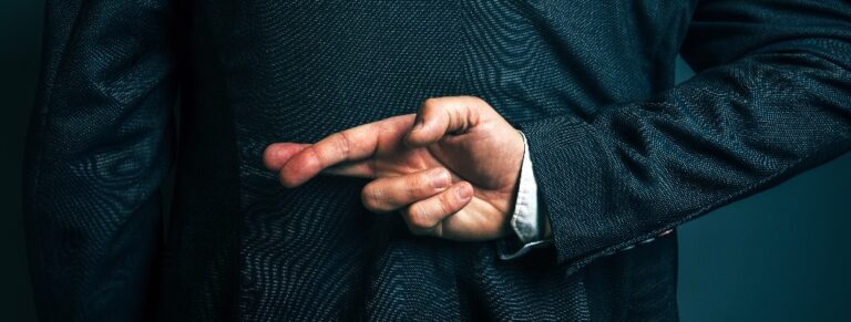 Lügender Geschäftsmann, der hinter seinem Rücken die Finger gekreuzt hält.