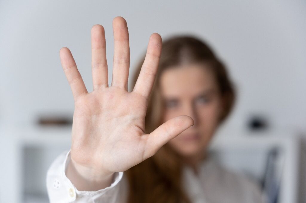 Frau, die mit der Hand ein Stoppzeichen macht.